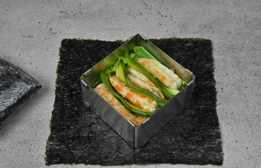 1. Этап. Суши сэндвич с креветкой: На овощи выложите по 4 крупные подготовленные креветки на порцию и ломтики авокадо.