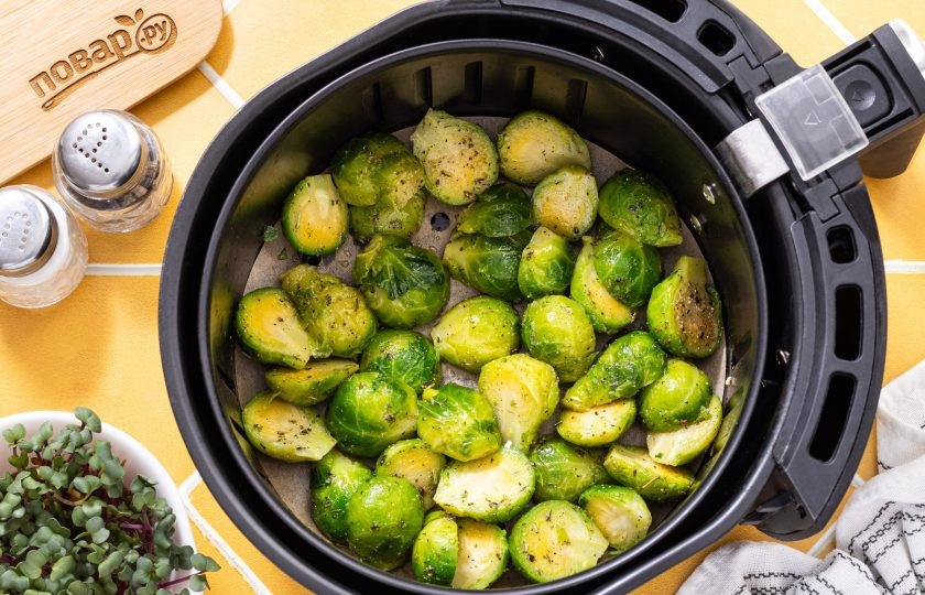 1. Этап. Брюссельская капуста в аэрогриле: Выложите брюссельскую капусту на решетку или в корзину аэрогриля. Дно я застелила пергаментом. Готовьте 12-15 минут при температуре 180 градусов до легкой румяной корочки.