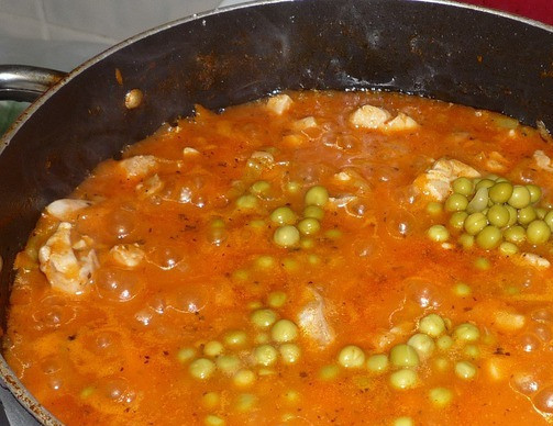 1. Этап. Гуляш из курицы с подливкой: Выкладываем обжаренные овощи в сковороду к курице, добавляем воду. Доливаем воду понемногу, при этом хорошо размешиваем содержимое сковороды. Затем добавляем соль, перец, специи и добавляем томатную пасту. Размешиваем, доводим до кипения. После этого добавляем зеленый горошек и тушим минут 8-10.