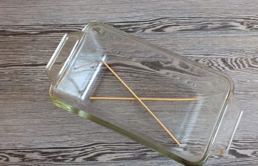 1. Этап. Буженина в вине: По истечении времени подготовьте форму для запекания. На дно выложите деревянные палочки.