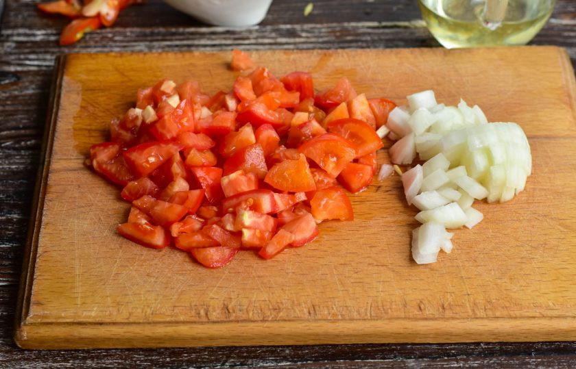 1. Этап. Овощное рагу без уксуса на зиму: Нарежьте мелкими кубиками помидоры и лук.