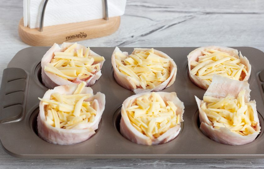 1. Этап. Мясные кексы с перепелиными яйцами: Выложите на яйца оставшийся фарш. По желанию смажьте небольшим количеством майонеза (можно без него) и присыпьте тертым сыром.