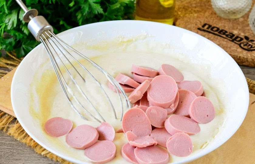 1. Этап. Оладьи с сосисками на кефире: Добавьте в тесто нарезанные молочные сосиски и размешайте.