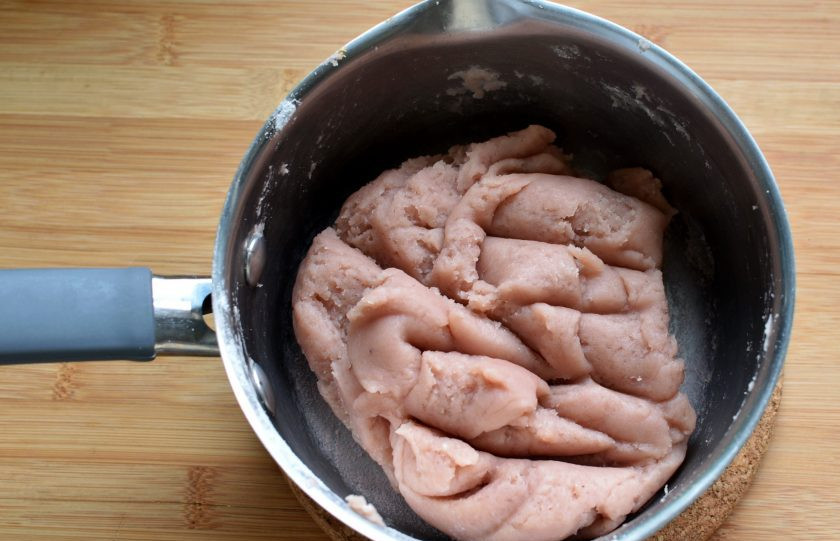 1. Этап. Эклеры Клубника со сливками: Всыпьте разом всю муку, активно размешивая ее лопаткой, прижимая ко дну кастрюльки и заваривая в плотный комок. Подсушите тесто при помешивании около минуты.