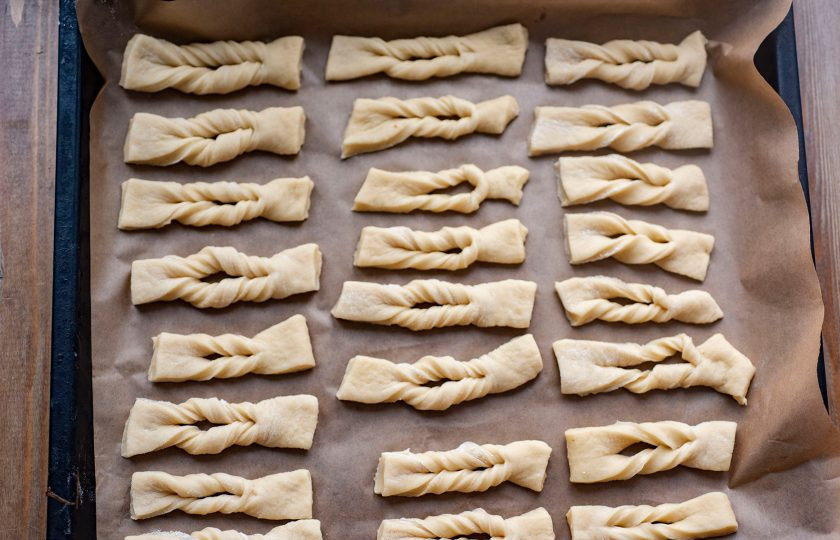 1. Этап. Хворост в духовке на кефире: Сделайте в прямоугольниках теста небольшие надрезы и выверните одну часть через отверстие, формируя заготовки хвороста. Все заготовки хвороста выложите на противень, застеленный пергаментом для выпекания. Отправьте заполненный противень в уже разогретую до 180 градусов духовку на 15-20 минут.