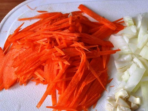 1. Этап. Капустная запеканка с фаршем в мультиварке: Порежьте лук, потрите морковь и обжарьте их в чаше мультиварки в течение 5 минут, периодически помешивая.