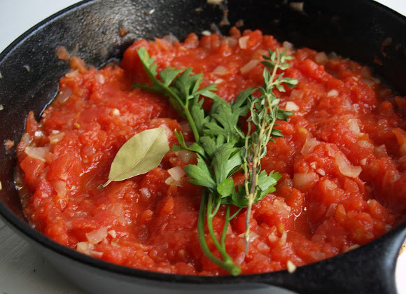 1. Этап. Рататуй: 3. Духовку включите нагреваться на 220-230 градусов. Застелите противень пергаментной бумагой. Выложите на противень приготовленный болгарский перец срезом вниз. Запекайте в разогретой духовке 20 минут. Затем снимите кожицу и мелко нарежьте. В сковороду влейте пару ложек масла, добавьте нарезанный небольшими кубиками лук, пропущенный через пресс чеснок и жарьте на медленном огне минут 8. Добавьте измельченные консервированные помидоры, их сок, 2 веточки тимьяна, измельченную петрушку (ложку), лавровый лист.