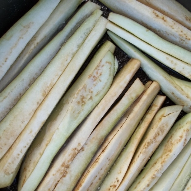 1. Этап. Сациви из баклажанов: Баклажаны нарезать на длинные и тонкие кусочки. Положить в сковороду с разогретым маслом, жарить на среднем огне под крышкой, пока не подрумянится одна сторона.