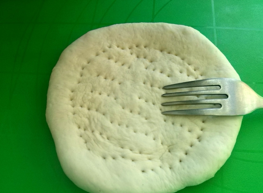 1. Этап. Токаш (лепешка): Разогрейте духовку до 180 градусов. Тесто разделите на 4 равные части, каждую из которых окуните в муку (обваляйте их в ней). Из каждой части теста сформируйте руками лепешку. В середине лепешки сделайте (пальцами) углубление, наколите его вилкой. Смажьте маслом противень, выложите на него лепешки. Выпекайте их до готовности (примерно 20 минут).