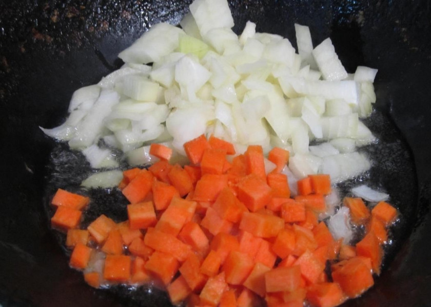 1. Этап. Суп вермишелевый с грибами: Лук мелко порубите, морковь порежьте небольшими кубиками, обжарьте вместе на растительном масле до мягкости.