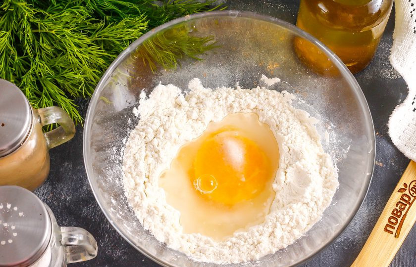 1. Этап. Пичи: Всыпьте в глубокую миску пшеничную муку высшего сорта, оставив 2 ст.л. на раскатку теста. Сделайте в муке углубление, всыпьте туда 2 щепотки соли, вбейте куриное яйцо и влейте воду.