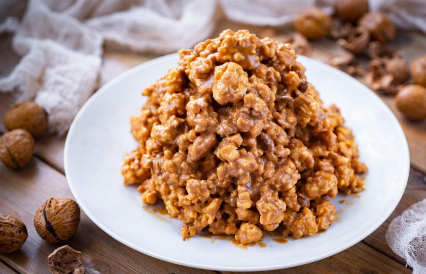 1. Этап. Торт Муравейник с медом: Всю массу из печенья и крема выложите на большое плоское блюдо и сформируйте руками торт в форме горки. Отправьте 