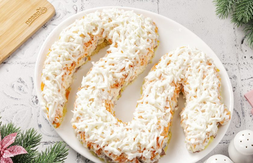 1. Этап. Селедка под шубой на год Змеи 2025: Далее выложите тертые белки (желтки оставьте для украшения). Посолите и смажьте майонезом.