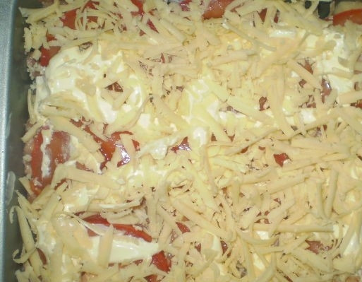 1. Этап. Картофельная запеканка с майонезом: 8. Натрите сыр. Равномерно присыпьте им запеканку сверху. Разогрейте духовку, установив температуру 200 градусов. Отправьте форму с блюдом в духовку на 35-40 минут.