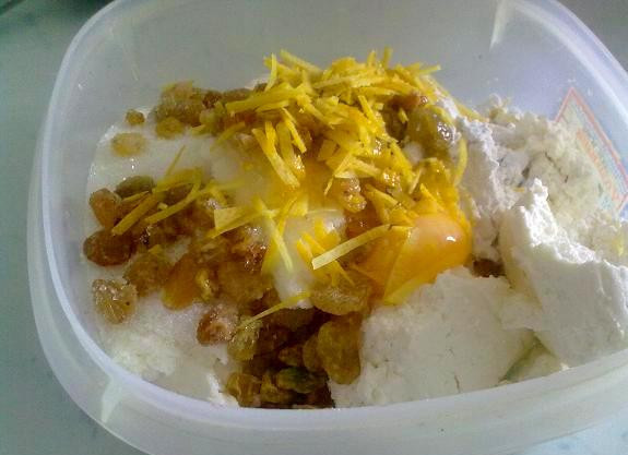 1. Этап. Булочки из слоеного теста с творогом: В отдельной емкости разотрите с сахаром один желток, добавьте туда же творог, ванильный сахар, цедру, изюм и крахмал. Все тщательно перемешайте.