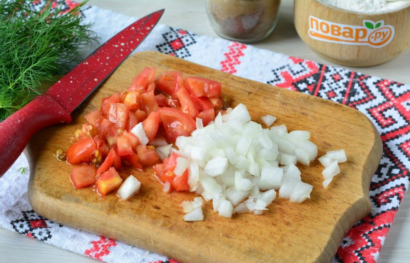 1. Этап. Овощной пирог из кабачков: Почистите лук и нарежьте его кубиками. Помидоры также нарежьте кубиками.