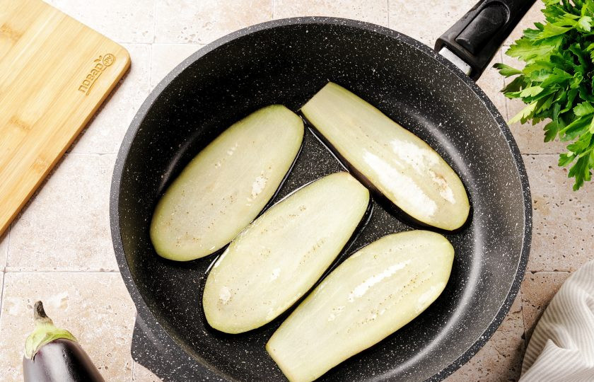 1. Этап. Рулет из баклажанов с сыром и корейской морковью: В горячую сковороду с подсолнечным маслом выкладывайте пластинки баклажана.