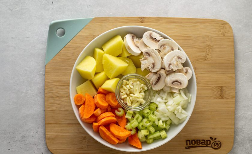 1. Этап. Овощное рагу без масла: Картофель и морковь помойте, очистите и нарежьте ломтиками среднего размера. Репчатый лук порубите кубиками, сельдерей кружочками. Грибы помойте, нарежьте ломтиками. Чеснок мелко измельчите.