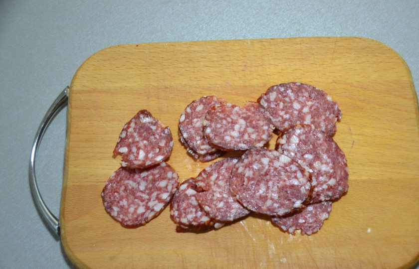 1. Этап. Пицца Миланская: Пока пицца в духовке, нарежьте тонкими слайсами салями.