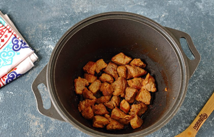 1. Этап. Лагман по-казахски: В казане разогрейте масло, выложите мясо и на сильном огне периодически помешивая, обжарьте до легкой румяной корочки.