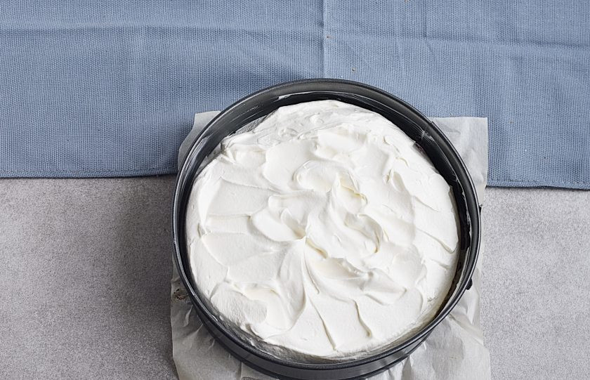 1. Этап. Торт с ягодами: Хорошо охлажденные густые сливки взбейте с отложенными двумя ложками сахара до жестких пиков. Покройте торт сверху и с боков.