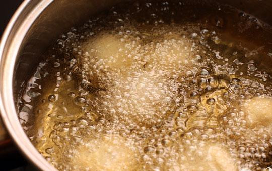 1. Этап. Куриные крокеты: 4. Разогреем в сотейнике масло для фритюра. Небольшими порциями (штук по пять-семь) опускаем туда шарики. Обжариваем примерно минуты три, шарики должны стать светло-золотистого цвета.