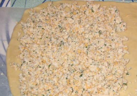 1. Этап. Пирог с колбасой и сыром: Раскатайте тесто в прямоугольный пласт. На одну половину теста выкладываем творожно-сырную начинку.