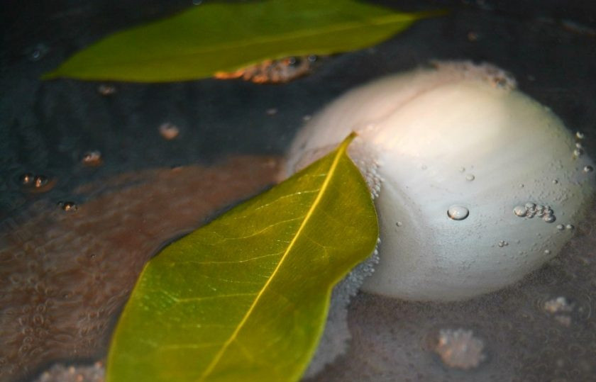 1. Этап. Вкусный и простой рыбный суп: 2. Почистите лук и положите его в воду, добавьте лавровый лист.