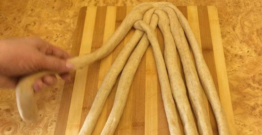 1. Этап. Постная плетенка из 7 жгутов: 5. Разделите жгуты так, чтобы слева осталось 4 жгута, а справа - 3. Скрепите их сверху между собой. Пронумеруйте жгуты с 1 по 7, начиная с крайнего левого жгута. Перекиньте 2 жгут через 1, а 1 через 3 и 4, положив его к остальным трем жгутам справа.