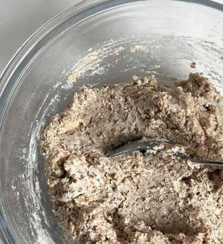 1. Этап. Гречневые уголки: Добавить растительное масло, перемешать и добавить просеяную муку и разрыхлитель, ложкой хорошо размешать. Муки может уйти больше или меньше, это зависит от консистенции йогурта и влажности муки. Тесто получается слегка липким.