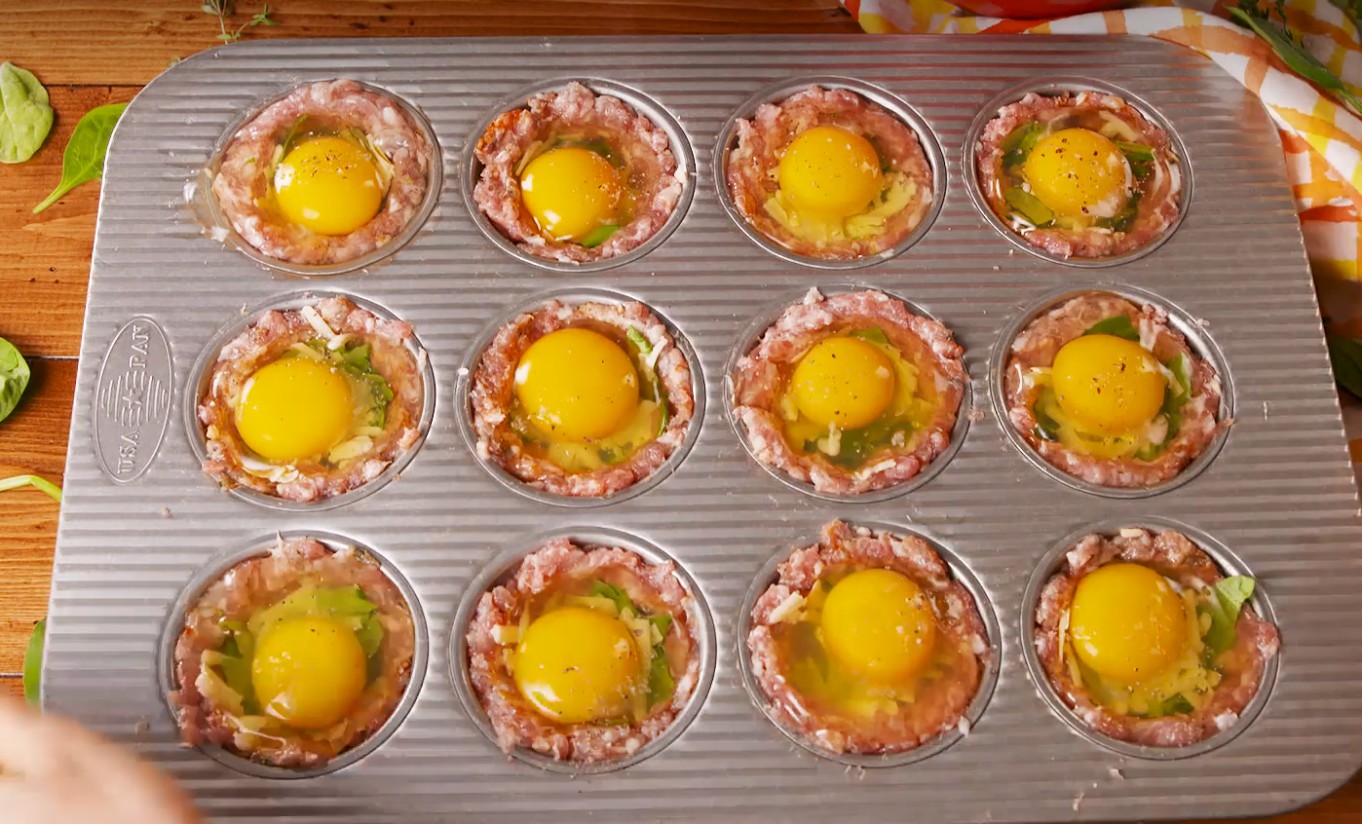 1. Stage. Breakfast Cups: Add a small handful of pork to each muffin tin well then press up the sides to create a cup. Divide spinach and cheese evenly between cups. Crack an egg on top of each cup and season with salt and pepper.