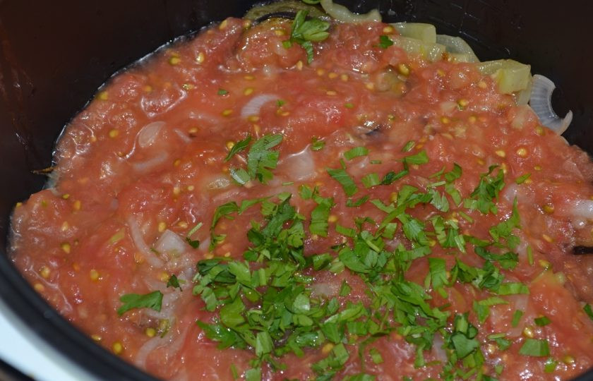 1. Этап. Аджапсандали по-грузински: Добавьте также поджаренный перец и залейте томатным соком. Добавьте пропущенный через пресс чеснок. Сверху присыпьте мелко порубленной зеленью. Немного посолите. Хорошо перемешайте и тушите на среднем огне 15 минут. В мультиварке я выставляю режим тушения при максимальной температуре на 20 минут.