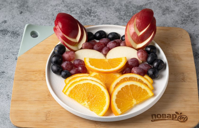 1. Этап. Фруктовая нарезка Дракон на Новый год: Затем в центр выложите виноград розового цвета, а по краю черного.