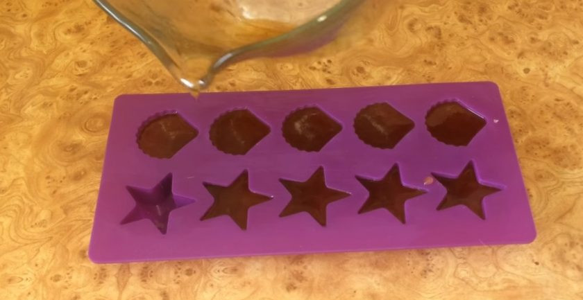 1. Этап. Леденцы на палочке своими руками: 3. Если капля смеси затвердевает в холодной воде, леденцы готовы. Формы для леденцов смажьте растительным маслом. Разлейте по формочкам леденцовую смесь.