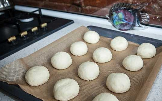 1. Этап. Королевские ватрушки с творогом: 6. Разделите его на 12 равных частей. Скатайте из каждой шарик и выложите на противень, застеленный пергаментом или ковриком. Оставьте еще минут на 15-20, чтобы они подошли.