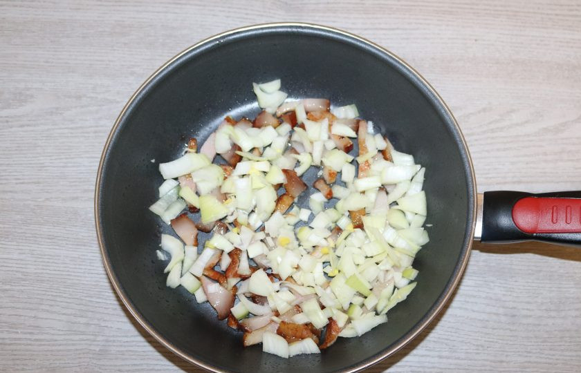 1. Этап. Коддл: К бекону добавьте лук, обжаривайте вместе.