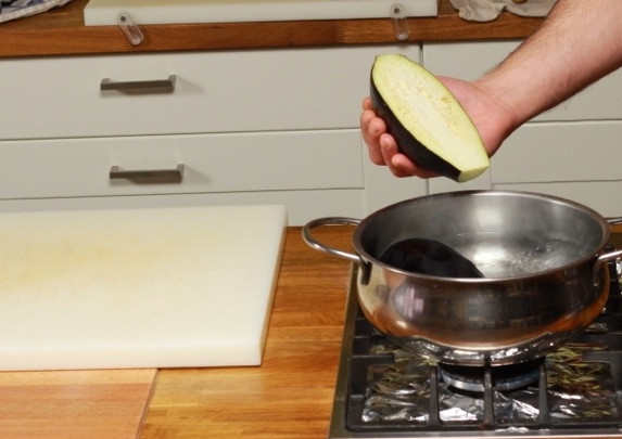 1. Этап. Баклажаны, фаршированные помидорами и сыром: Баклажаны разрежьте пополам, бросить в кипящую подсоленную воду и отварить в течение 5 минут.