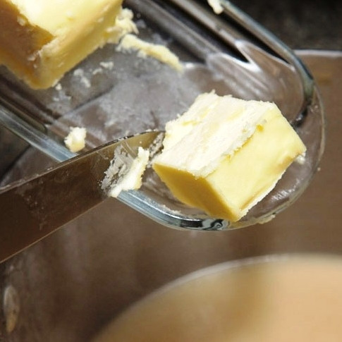 1. Этап. Гарнир из цветной капусты: Когда соус по консистенции станет напоминать жирные сливки, снимаем его с огня, добавляем в него примерно столовую ложку сливочного масла. Перемешиваем.