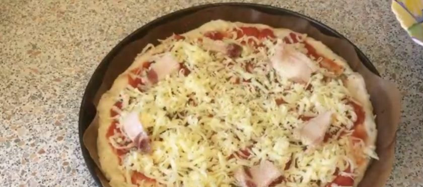 1. Этап. Пицца с беконом и ананасом (Гавайская): 5. Оставьте тесто для отдыха на 15-20 минут. Распластайте тесто в толстый пласт размером с будущую пиццу. Распределите по нему консервированные измельченные томаты, специи, черный перец и тертый сыр.