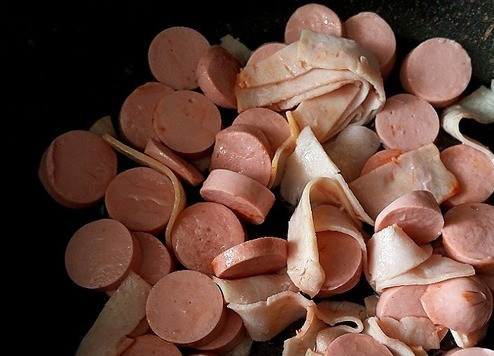 1. Этап. Солянка День 1 января: На сковороду наливаем масло, греем его и выкладываем сосиски и ветчину, порезанные произвольно (как вам нравится). Обжариваем немного. Перекладываем сосиски с ветчиной на тарелку.