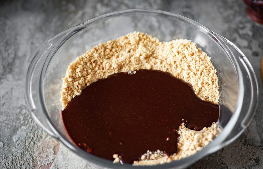 1. Этап. Колбаска Mинутка из печенья: В просторную миску выложите всю песочную крошку из чаши измельчителя и залейте шоколадную смесь.