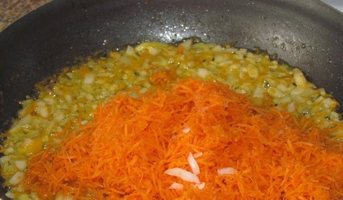 1. Этап. Тефтели с подливой в духовке: Лук мелко нарезаем, а морковь трем на крупной терке. В сковороде разогреваем растительное масло и обжариваем на нем вначале лук, а затем добавляем морковь. Жарим, пока овощи не станут мягкими.