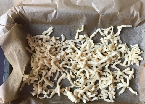 1. Этап. Пирожное Творожная нежность: 4. Через 20 минут начинаем по одной доставать колбаски теста из морозилки. Натираем на крупную терку на дно нашей формы (форму лучше застелить пергаментом). Натереть нужно примерно 2/3 теста.