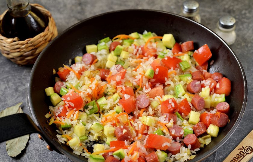 1. Этап. Рис с колбасками и овощами: Тщательно промойте рис, переложите в сковороду, перемешайте.