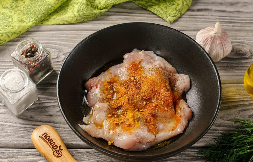 1. Этап. Курица по-арабски в духовке: Переложите отбитое филе в глубокую тарелку, добавьте давленый чеснок, растительное масло, лимонный сок, соль и специи по вкусу. Перемешайте и оставьте мариноваться на 20-30 минут.