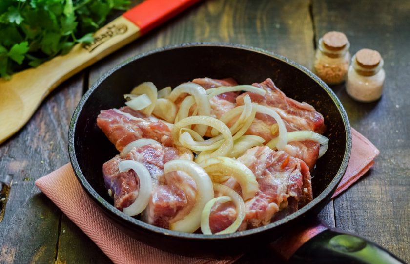 1. Этап. Свиные ребрышки в апельсиновом маринаде: Сковороду прогрейте и смажьте маслом, выложите в сковороду лук и ребра.