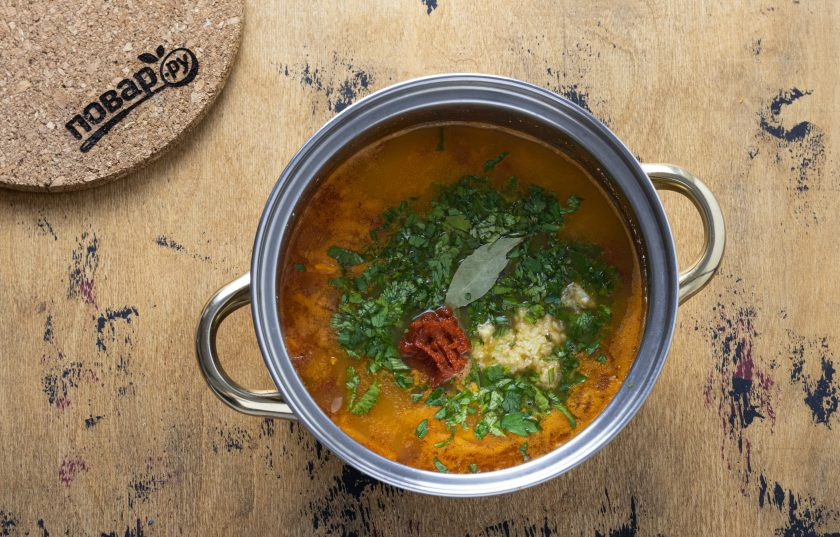 1. Этап. Грузинский суп из фасоли с овощами: Затем добавьте в кастрюлю лавровый лист, мелко порубленную зелень и чеснок. Посолите, приправьте аджикой. Варите суп еще 5-6 минут.