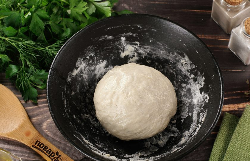 1. Этап. Деревенская пицца с творогом: Руками замесите мягкое и чуть липкое тесто. Если тесто сильно липнет к рукам, то можно добавить ещё 1-2 ст.л. муки. Соберите тесто в шар, смажьте растительным маслом, накройте и оставьте на 1-1,5 часа в тёплом месте.