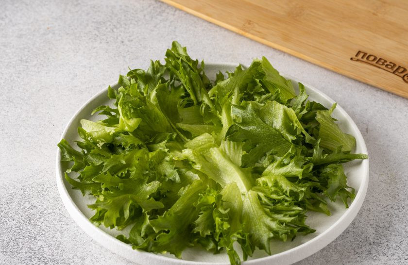 1. Этап. Оранжевый салат с мандаринами и хурмой: Выложите на тарелку салатные листья.