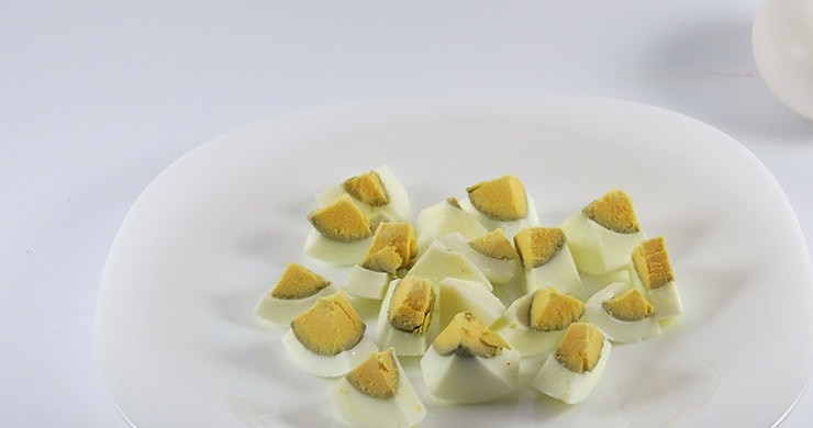 1. Этап. Цезарь со свининой: Отварите яйца в подсоленной воде. Яйца варите вкрутую примерно минут 10. Очистите яйца от скорлупы и порежьте на четвертинки. Томаты вымойте и порежьте некрупными кусочками. Пару листов салата выложите на тарелку, полейте немного соуса на них.